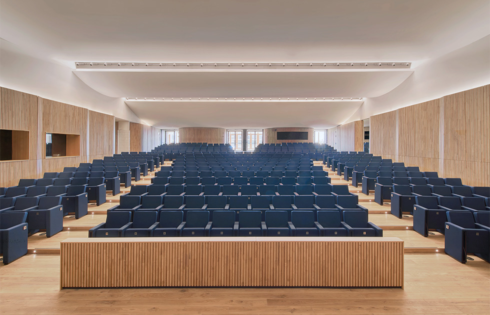 View of the auditorium, featuring tiered seating and warm wooden accents designed for optimal acoustics and comfort.